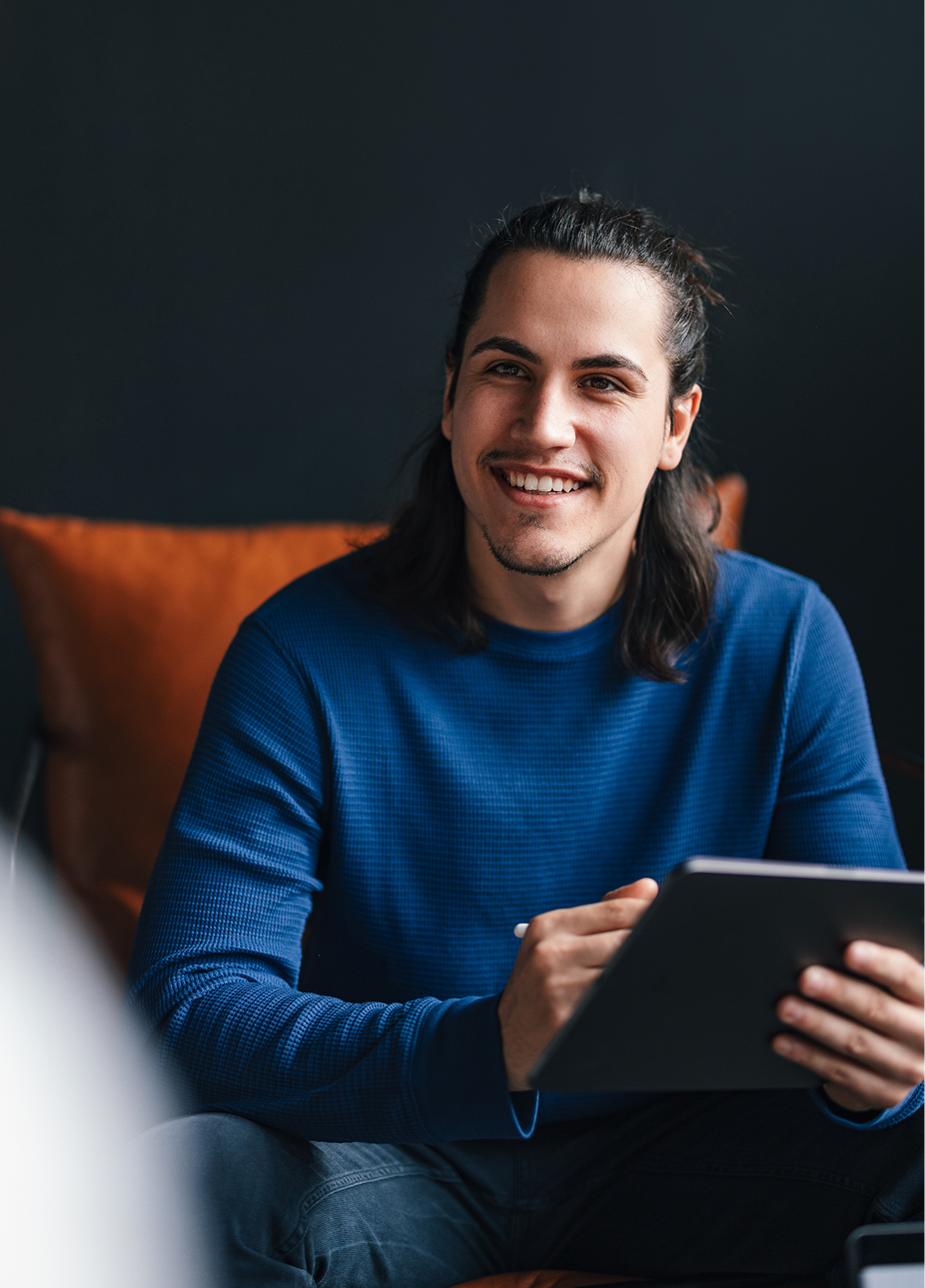 An engineer in a blue sweater holding a tablet