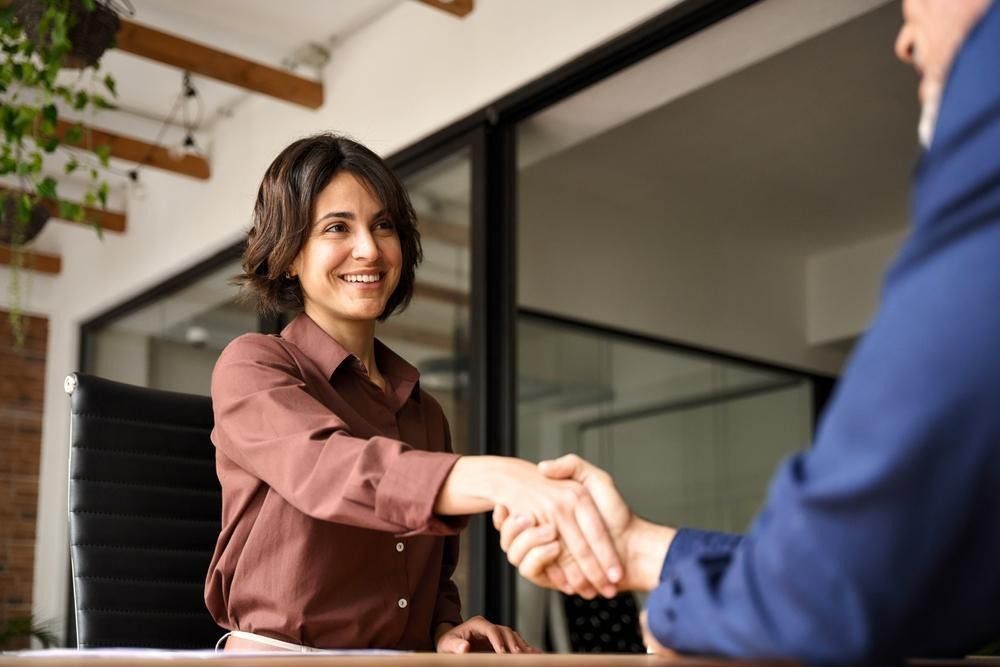 Two people shaking hands in an office.