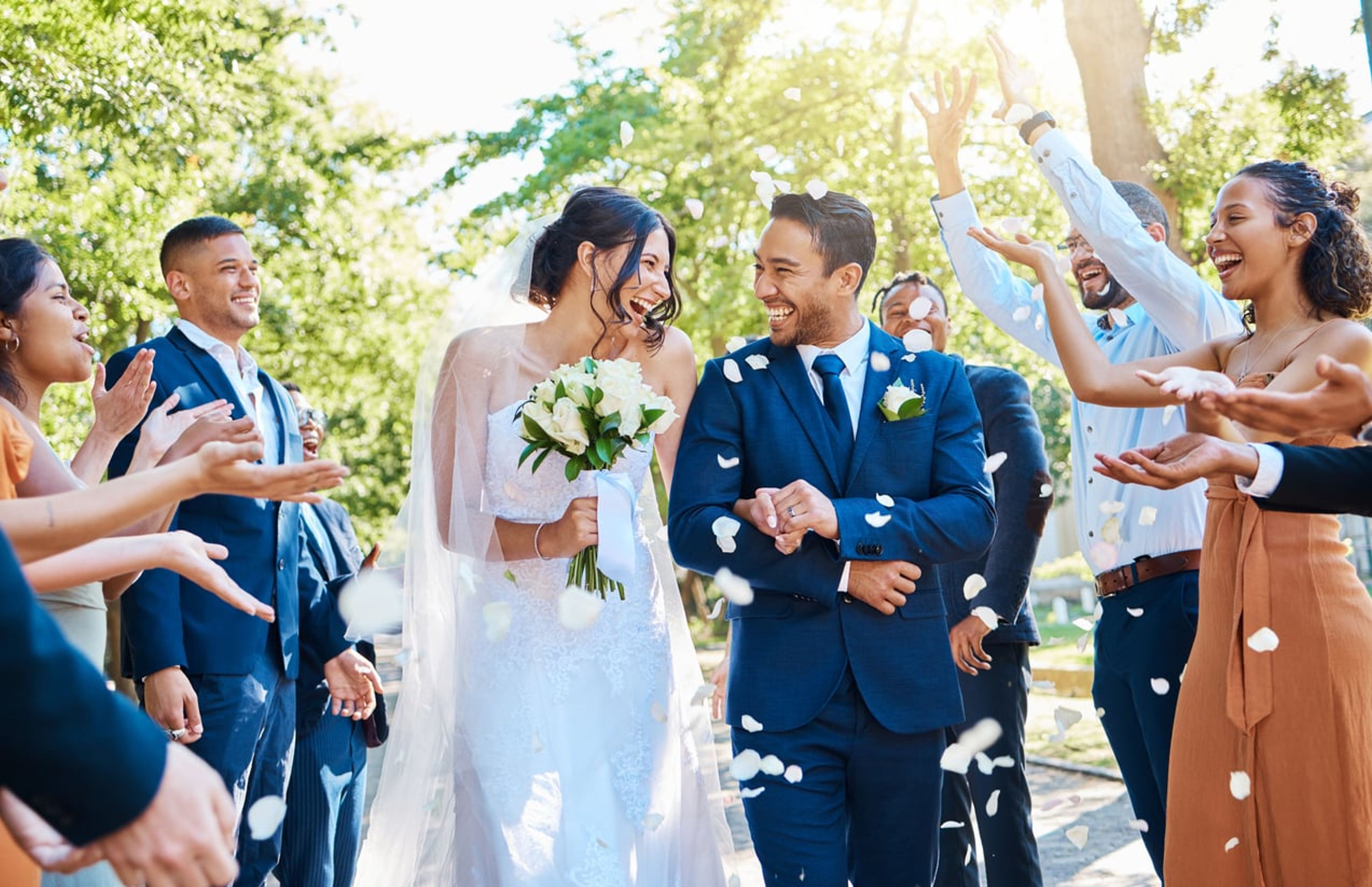 A happy couple on their wedding day surrounded by guests.