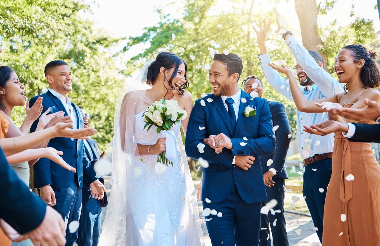 A happy couple on their wedding day surrounded by guests.