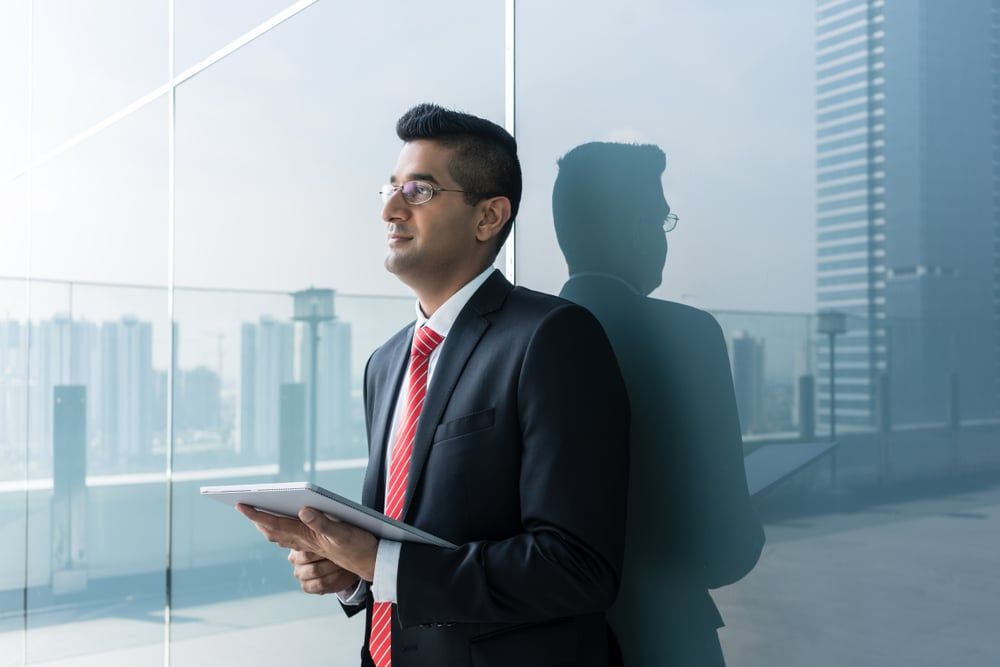 Investor standing on a terrace looking upward.