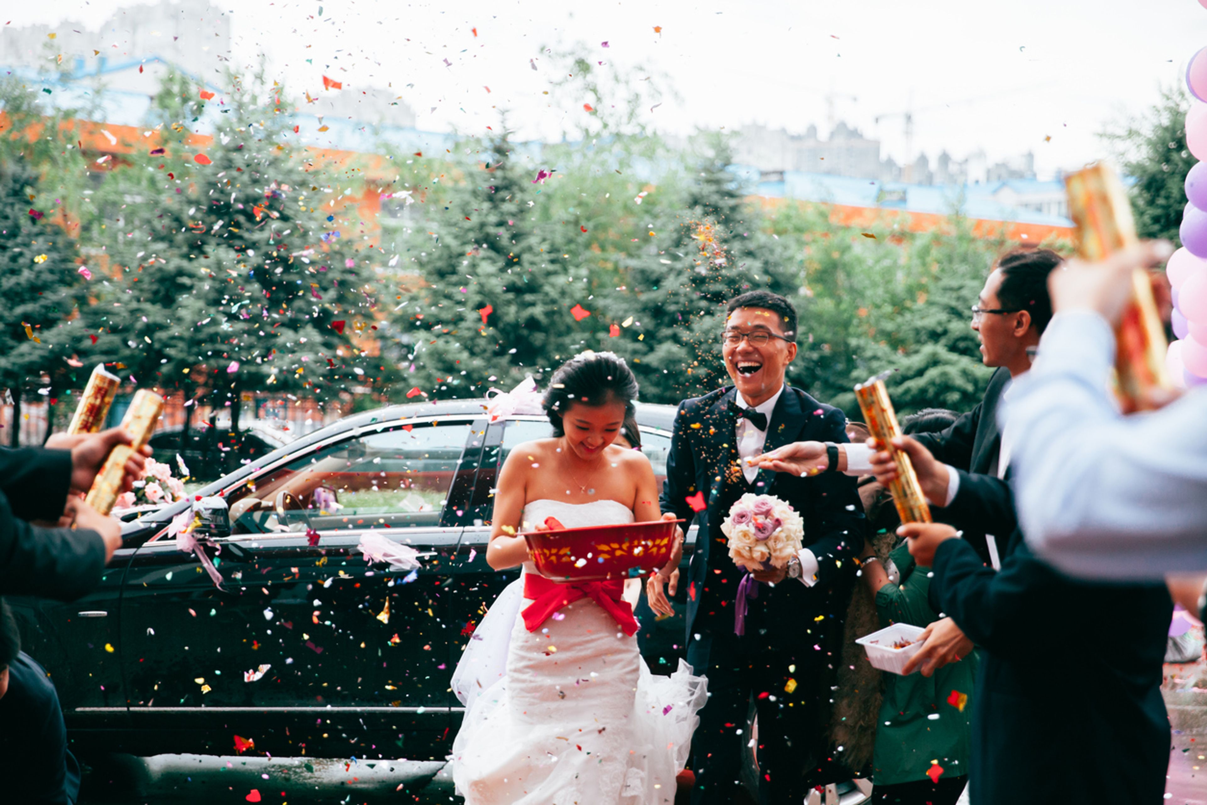 Bride and groom celebrating their wedding outside.