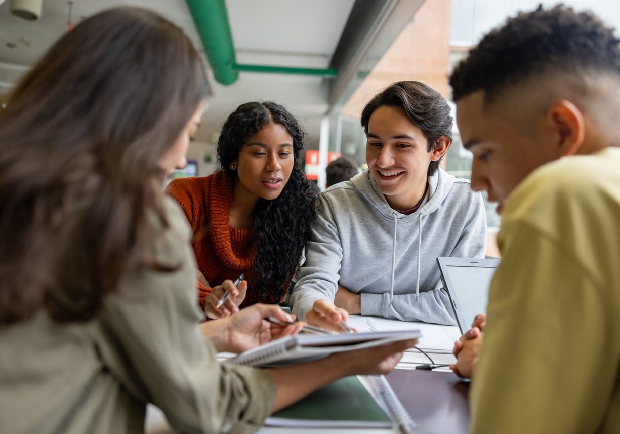 Group of young students working together at the library.