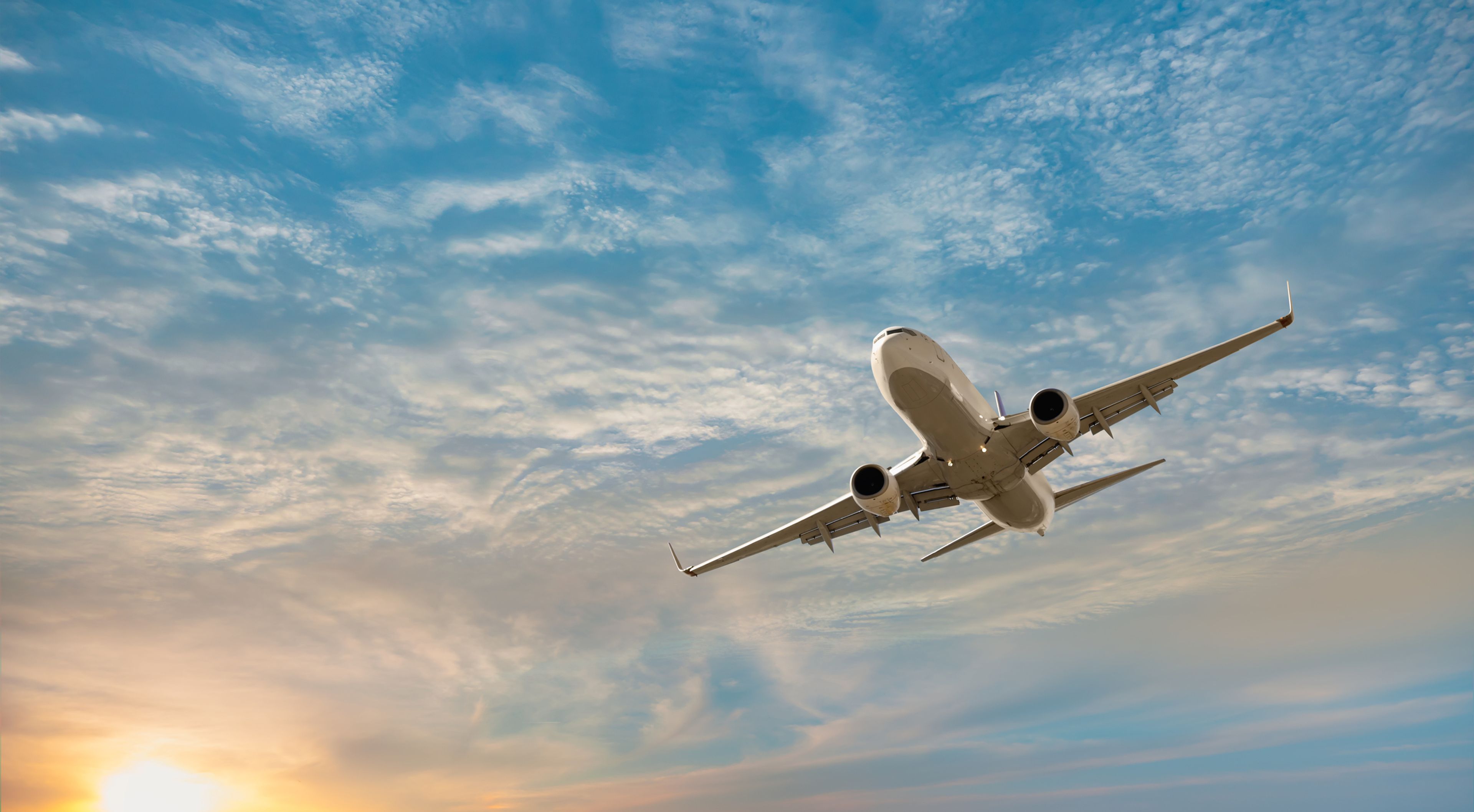 Commercial airplane flying over the sky, illustrating how travel on advance parole can now trigger the 3- or 10-year unlawful presence bar