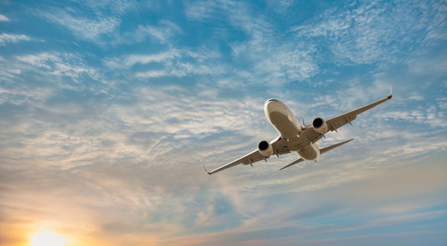 Commercial airplane flying over the sky, illustrating how travel on advance parole can now trigger the 10-year unlawful presence bar