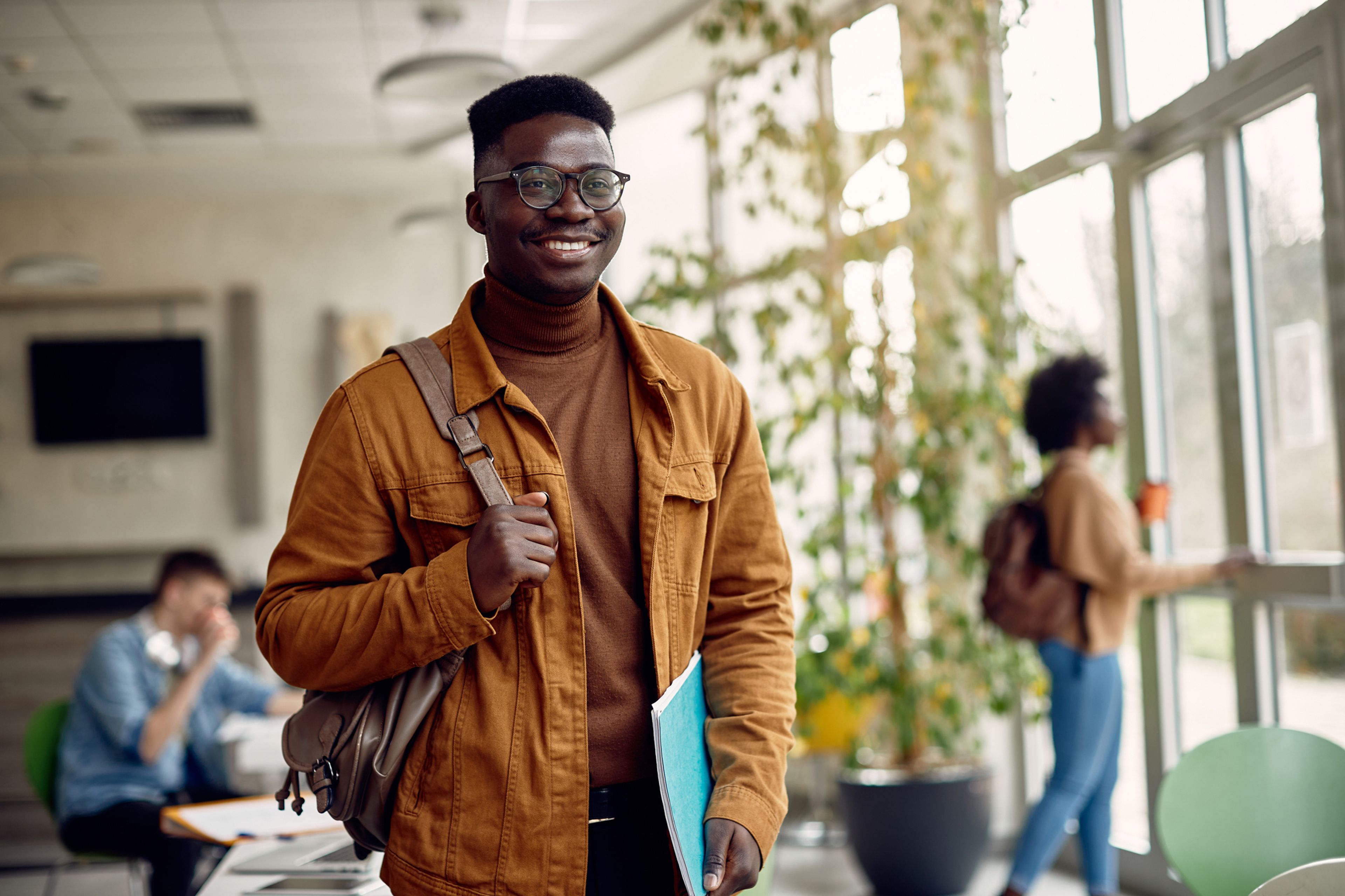 A young college student stands smiling as he prepares to begin his F-1 visa program.