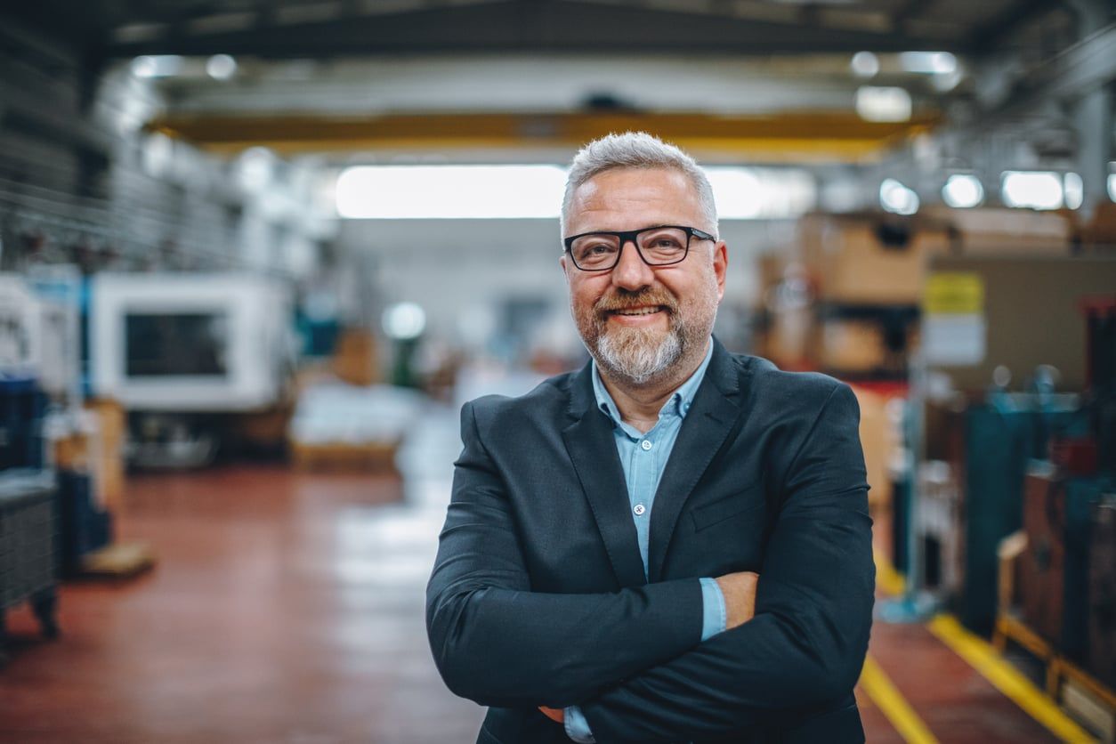 Industrial office manager standing confidently with arms crossed.