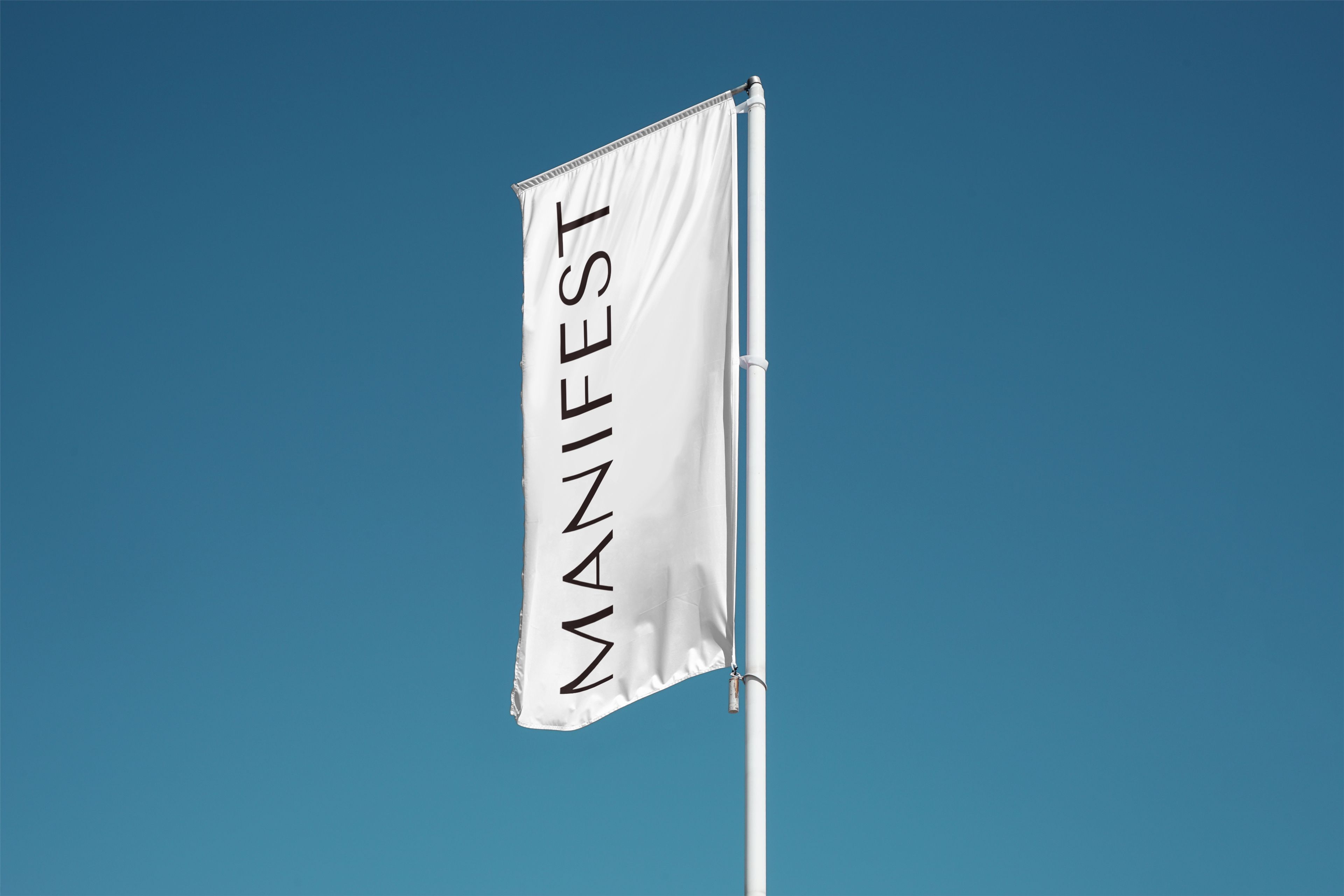 Manifest flag flying against a blue sky.