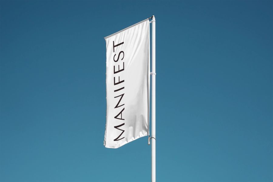 Manifest flag flying against a blue sky.