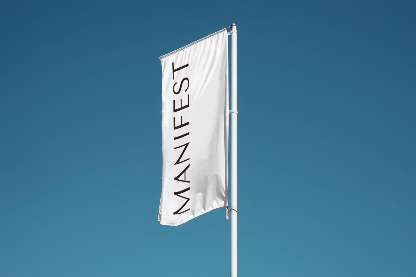 Manifest flag flying against a blue sky.