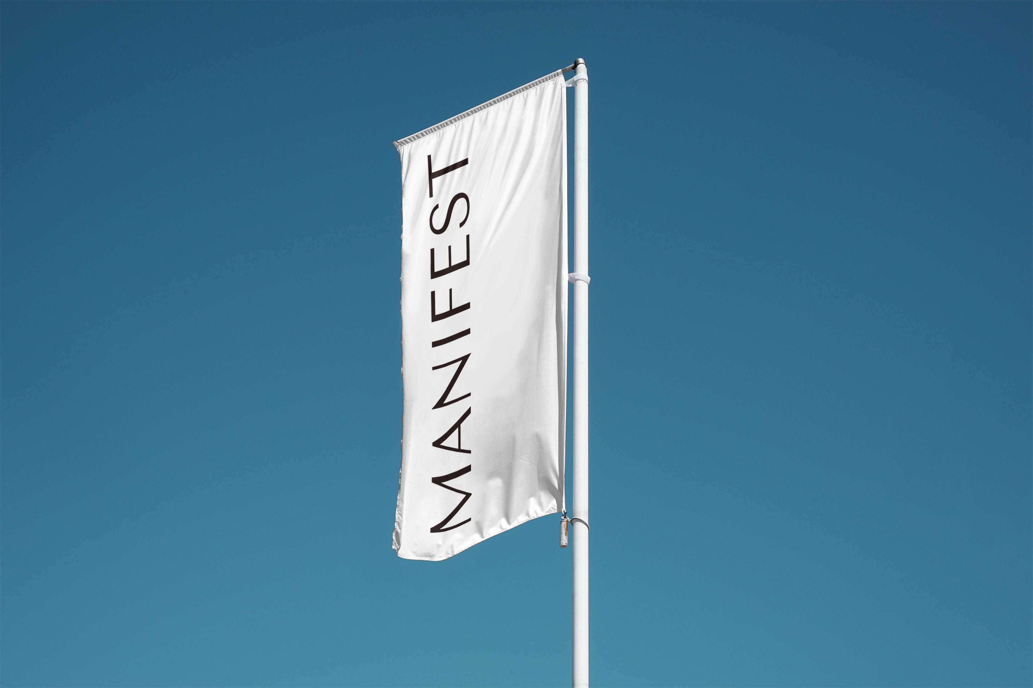Manifest flag flying against a blue sky.