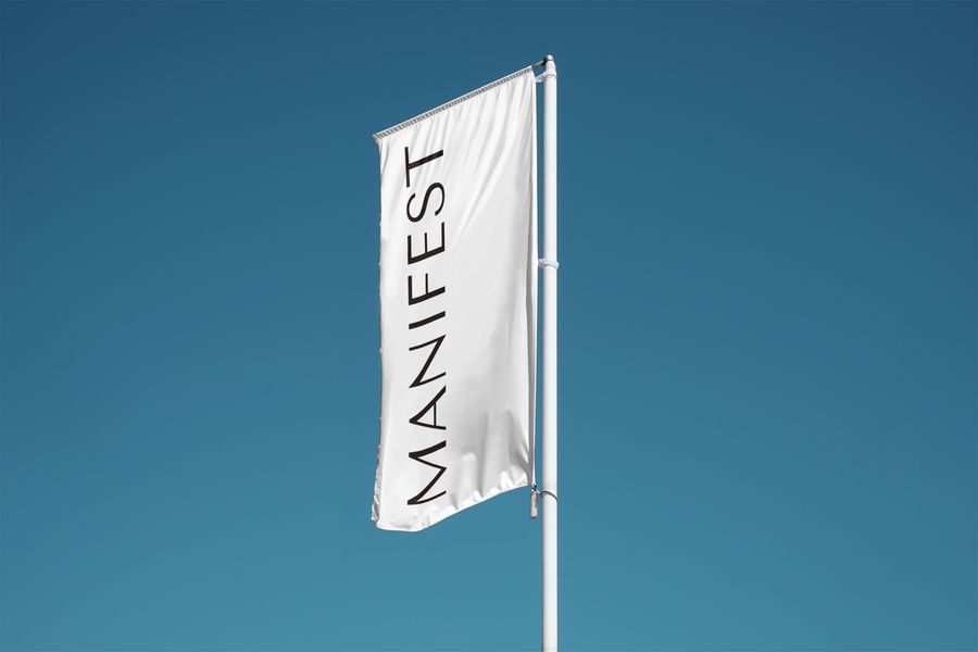 Manifest flag flying against a blue sky.