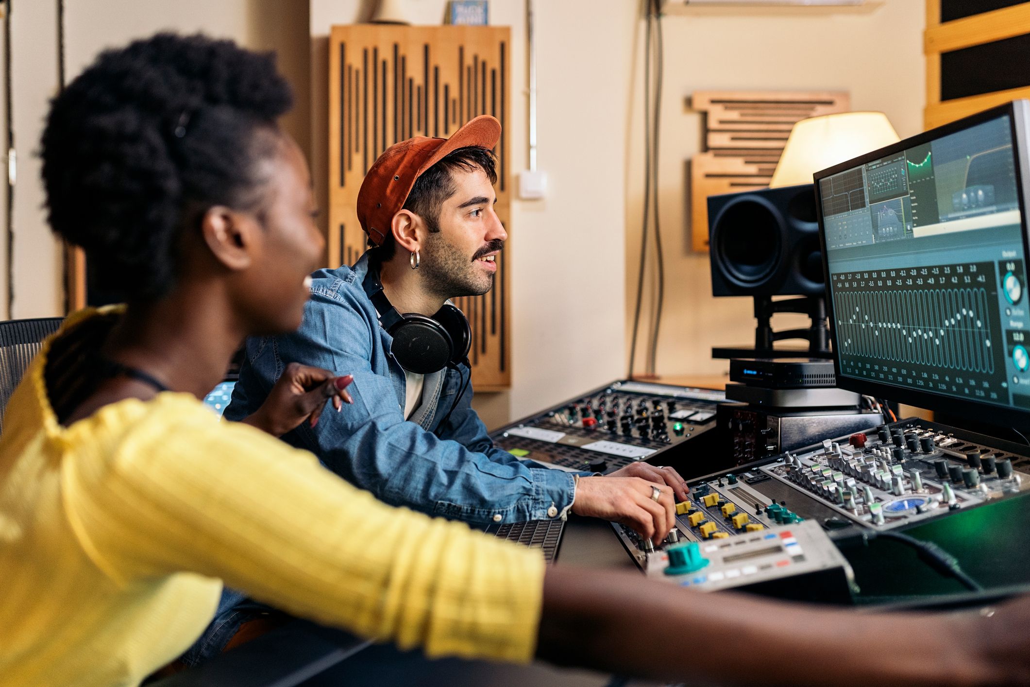 Two music producers working on a DAW to create music
