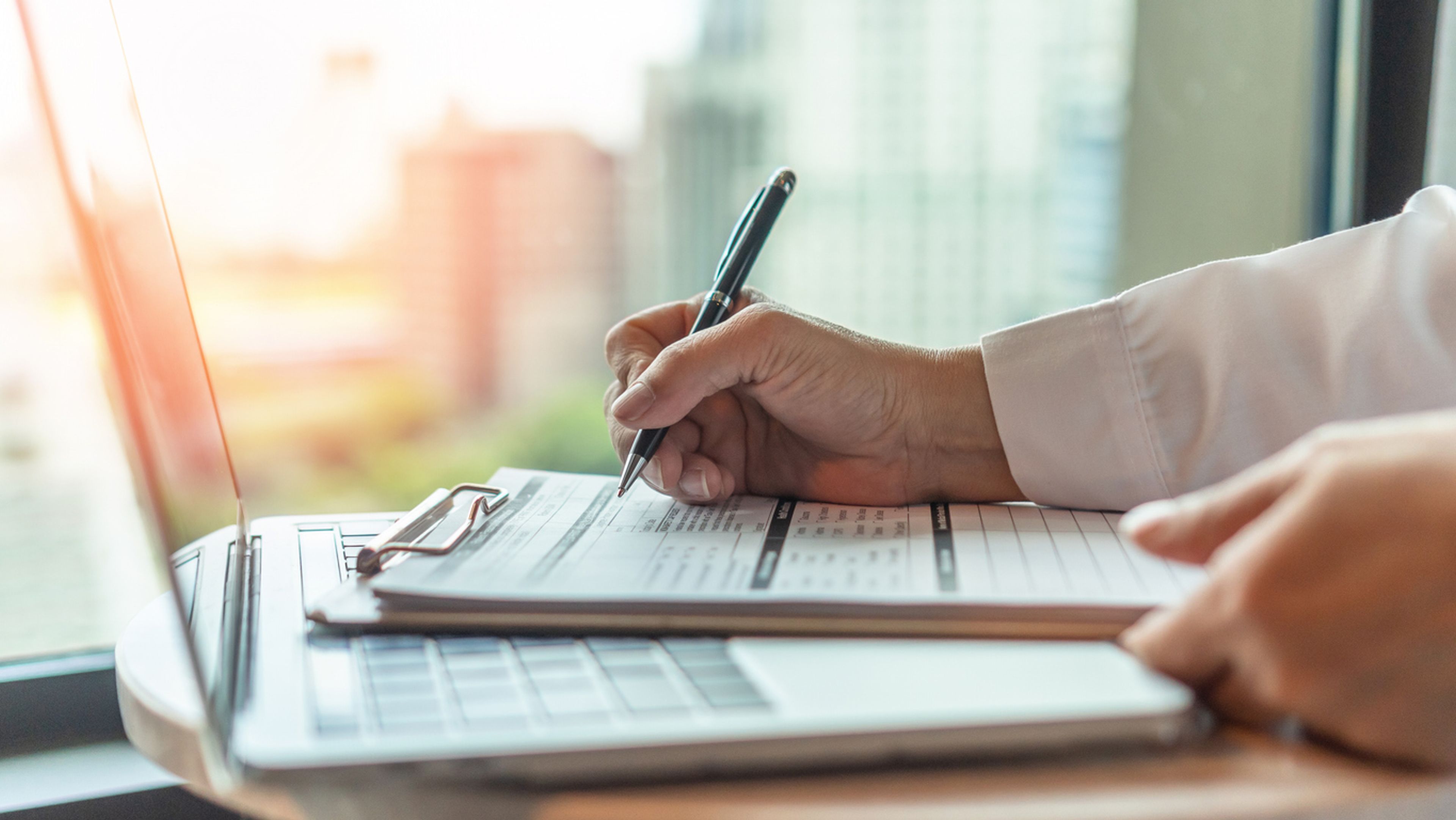 Person filling out a medical intake form at a doctor's office, representing the DHS public charge final rule's health coverage considerations