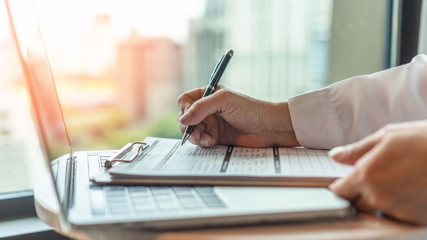 Person filling out a medical intake form at a doctor's office, representing the DHS public charge final rule's health coverage considerations