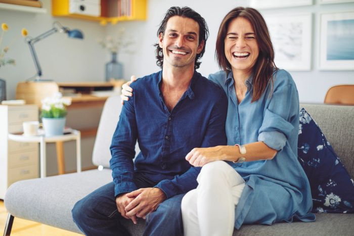 Two siblings sitting together for a family portrait on the couch