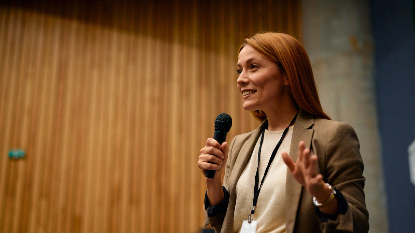 A researcher speaking into a microphone at a conference