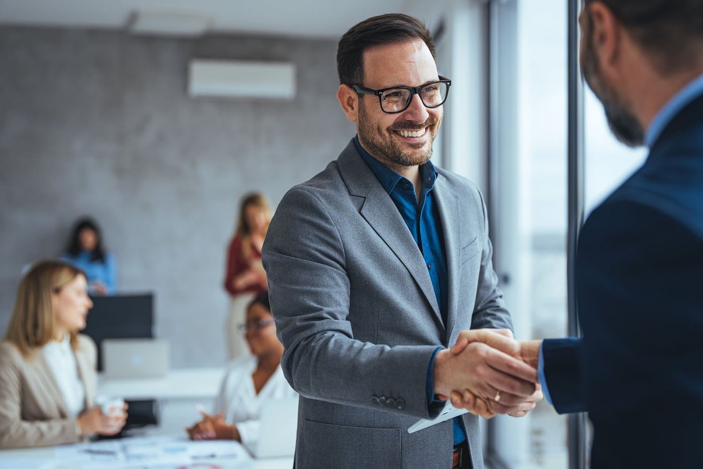 Two businessmen shaking hands and smiling
