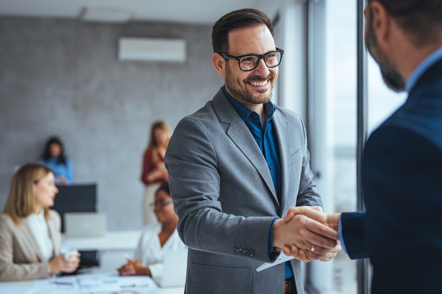 Two businessmen shaking hands and smiling