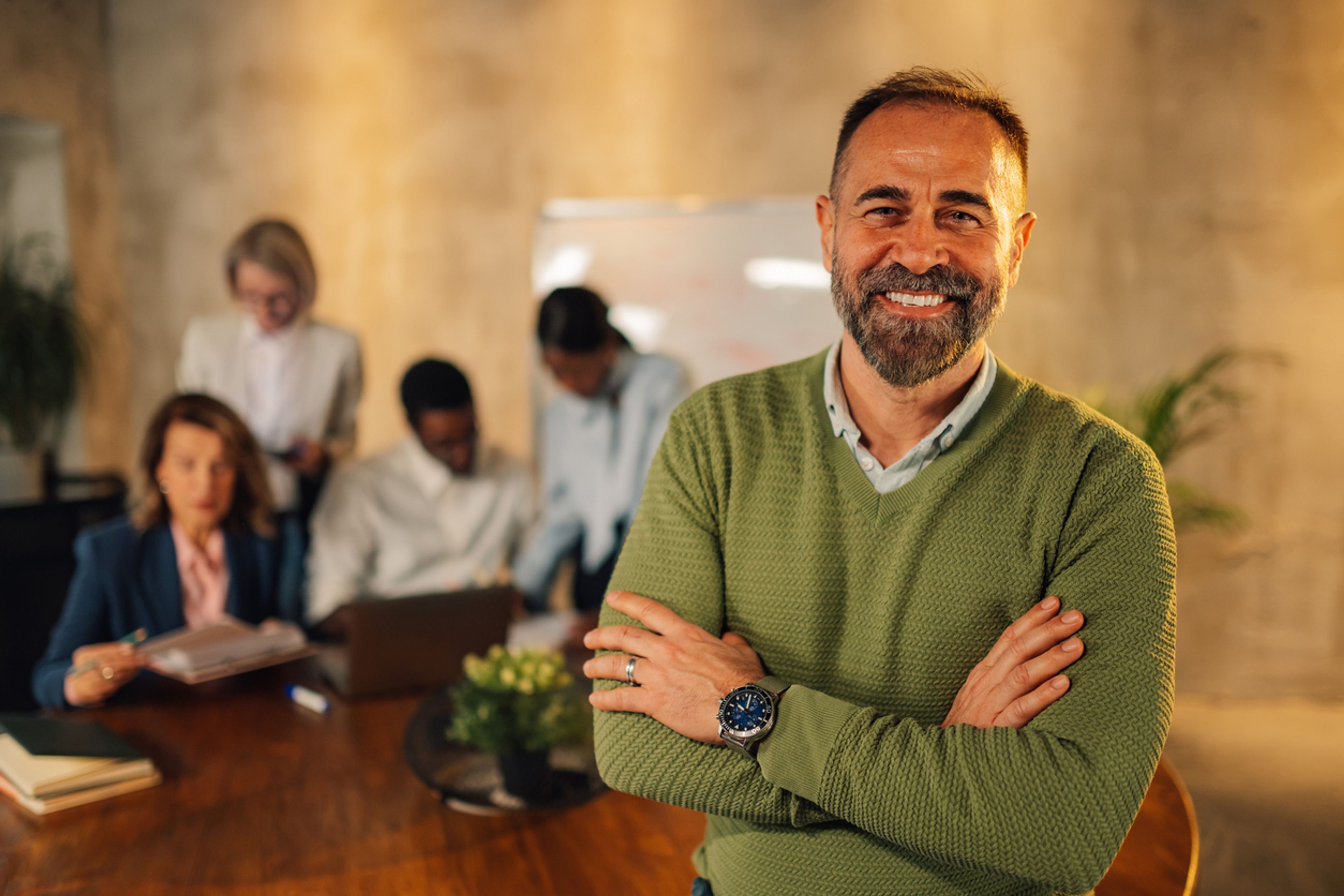 Business executive standing in front of a meeting with his workers.