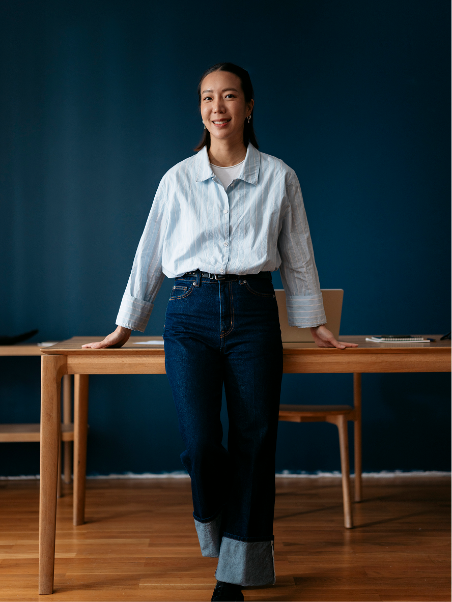 A founder standing confidently by a desk in an office