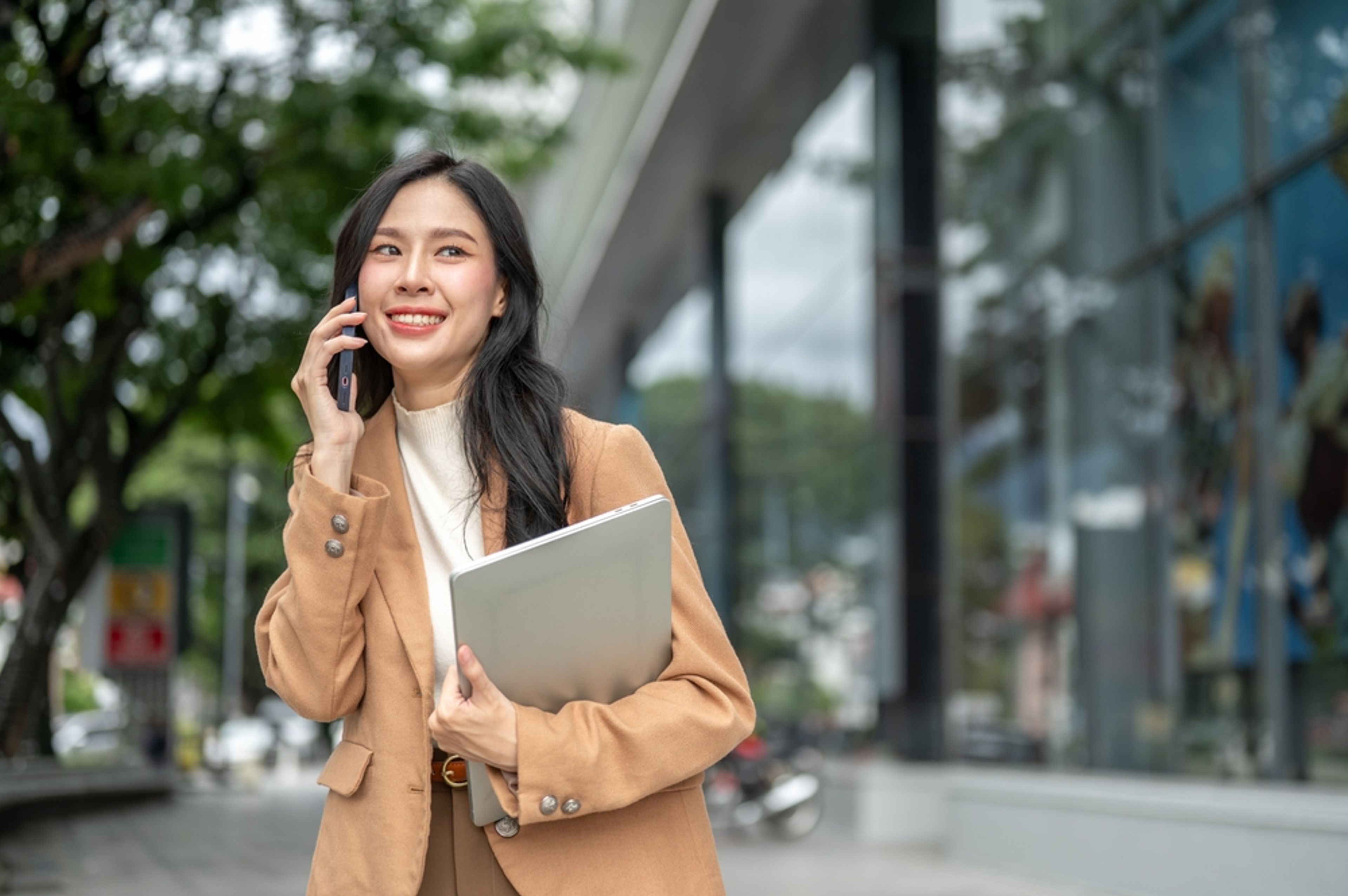 Happy professional tech worker taking a call outside.