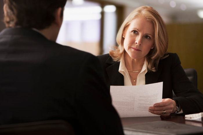 A woman in a suit interviews an O-1 visa candidate.