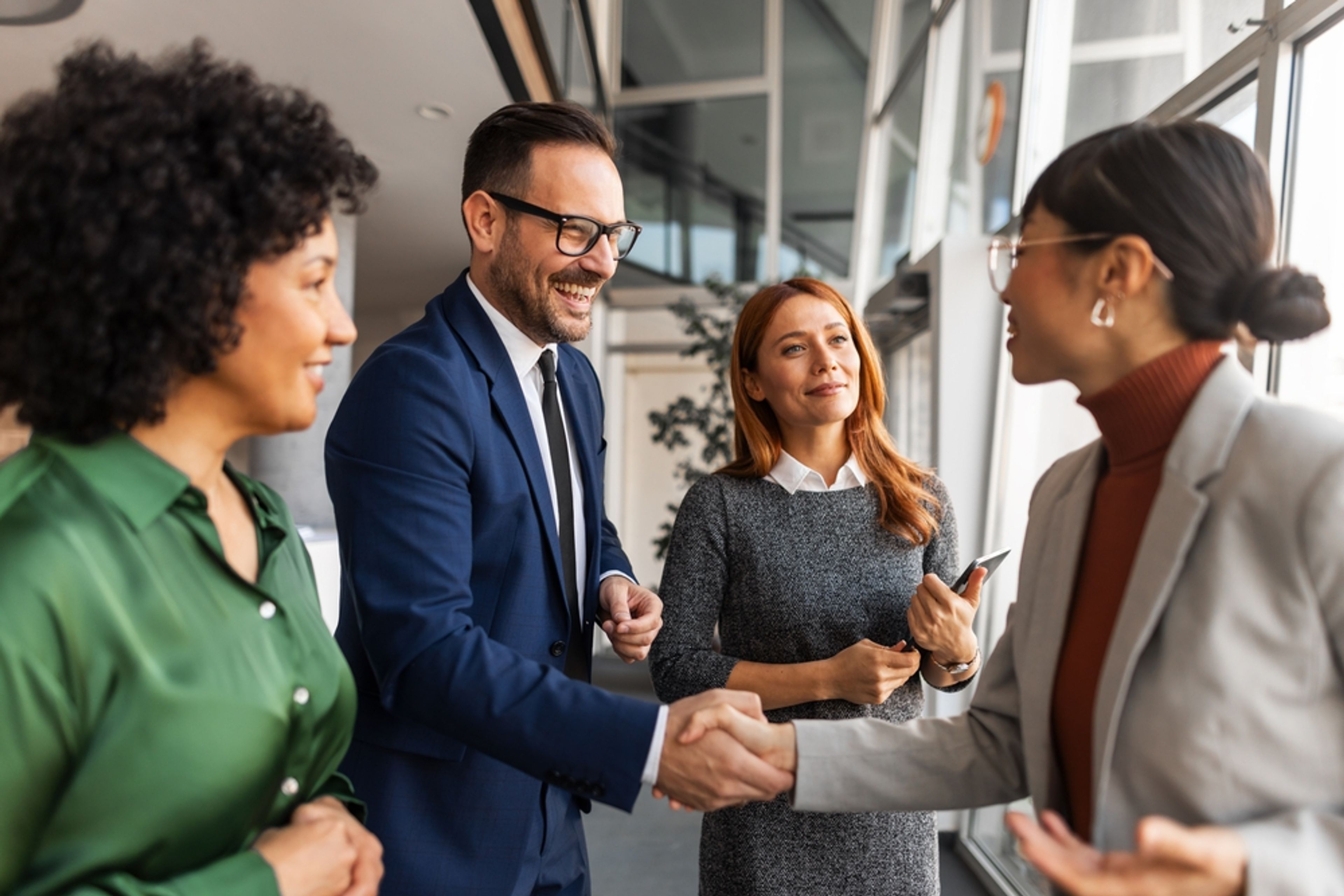 New worker shaking hands with her colleagues.