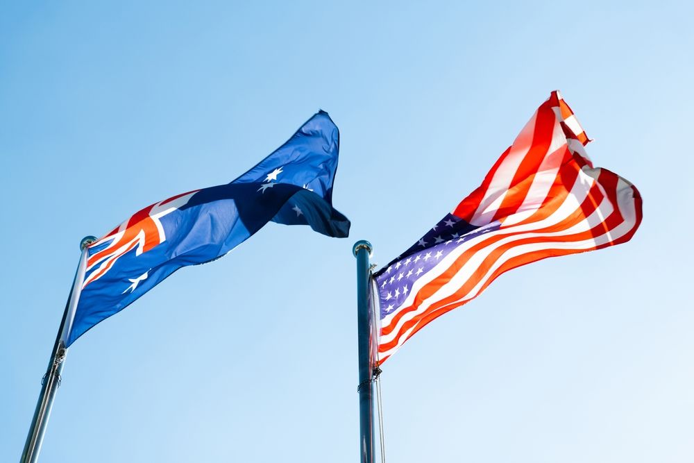 Australian and American flags flying in the wind.