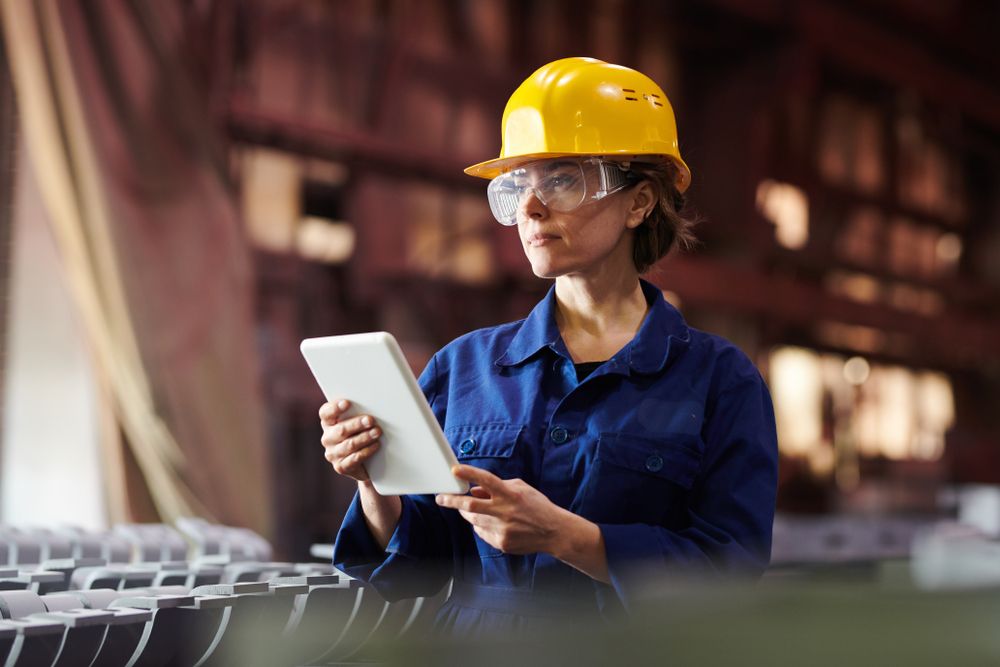 Female worker wearing hardhat and uniform on a jobsite.