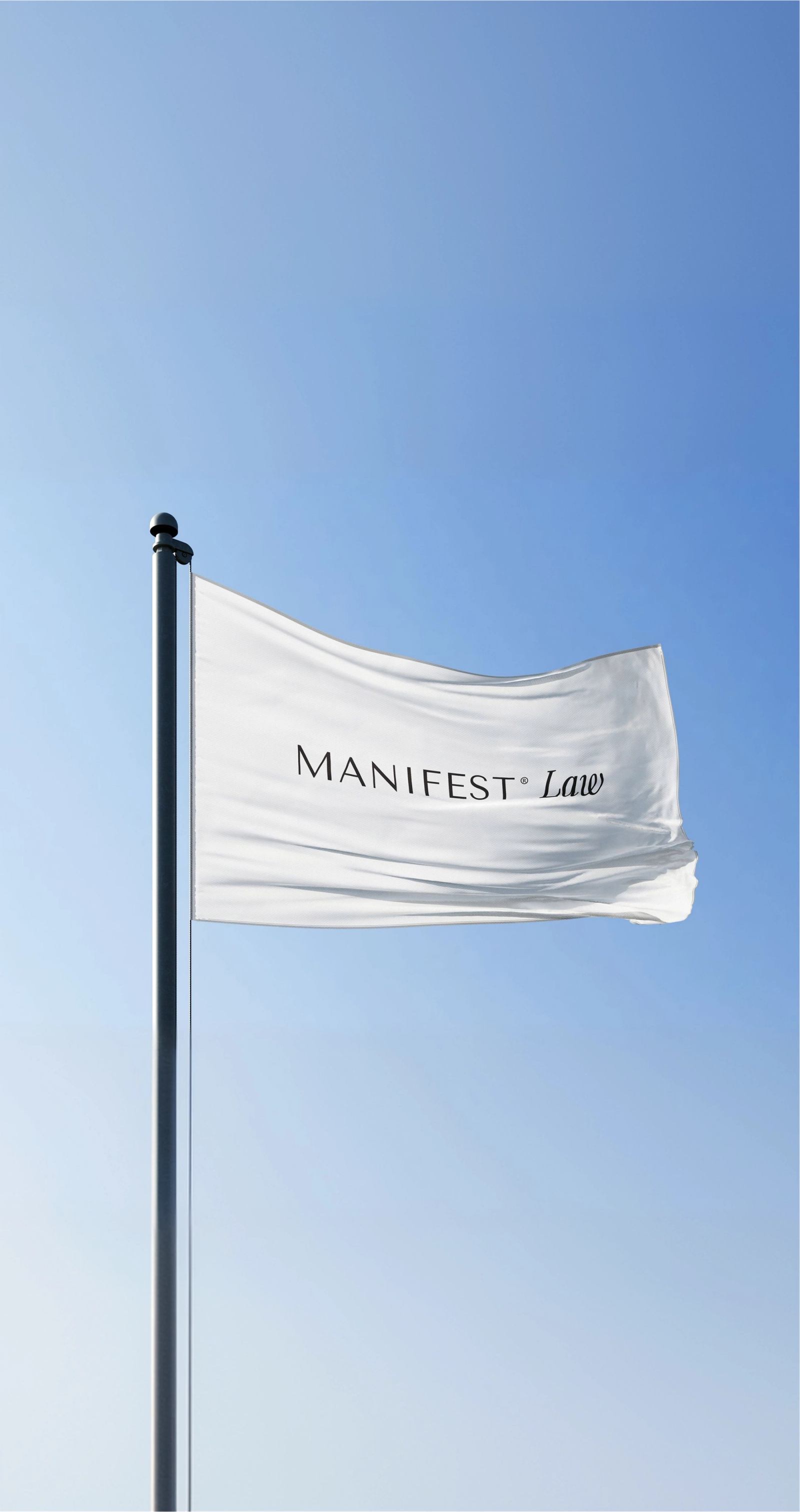 White Manifest Law flag waving against a blue sky.