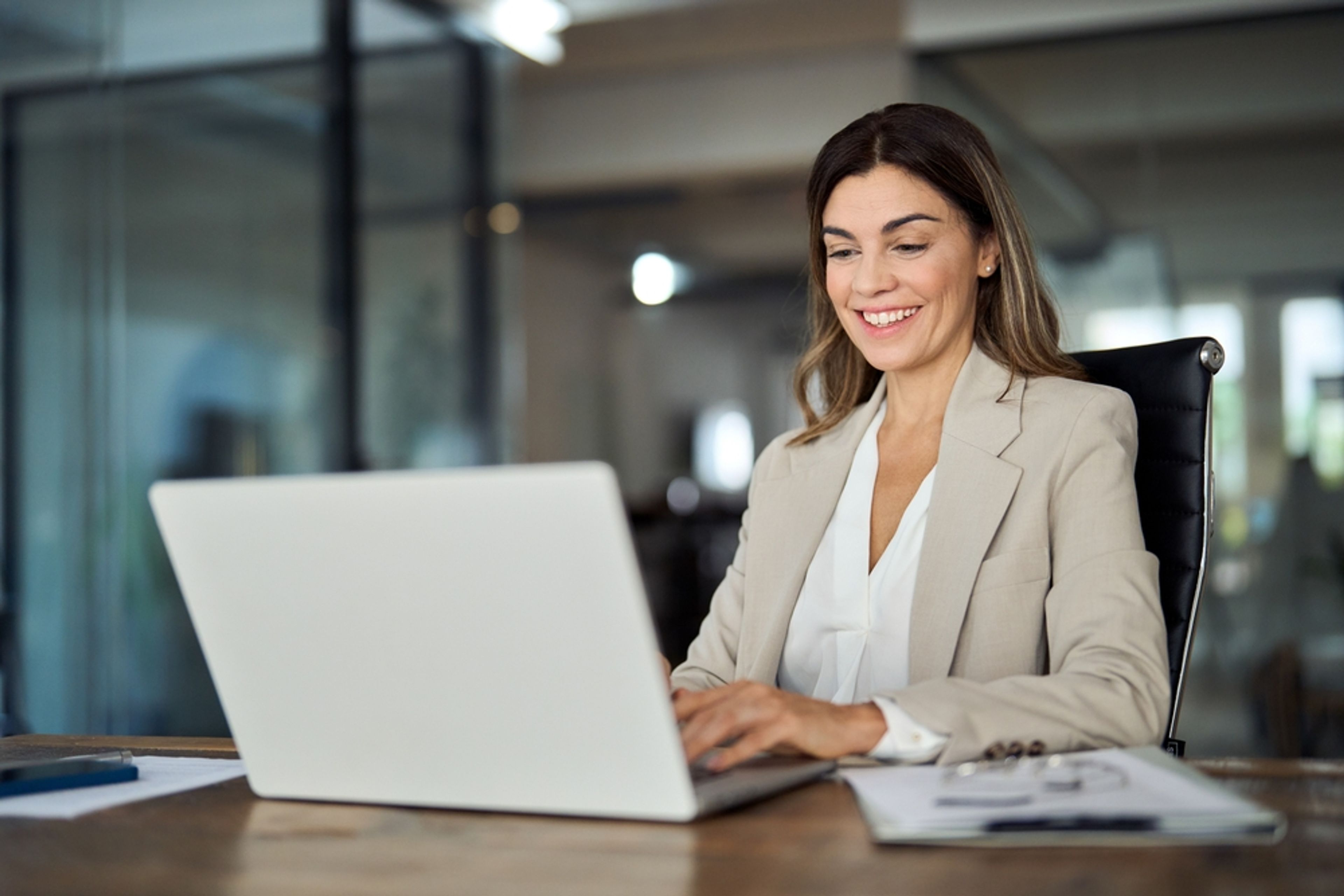 Professional working at a laptop while holding concurrent H-1B employment