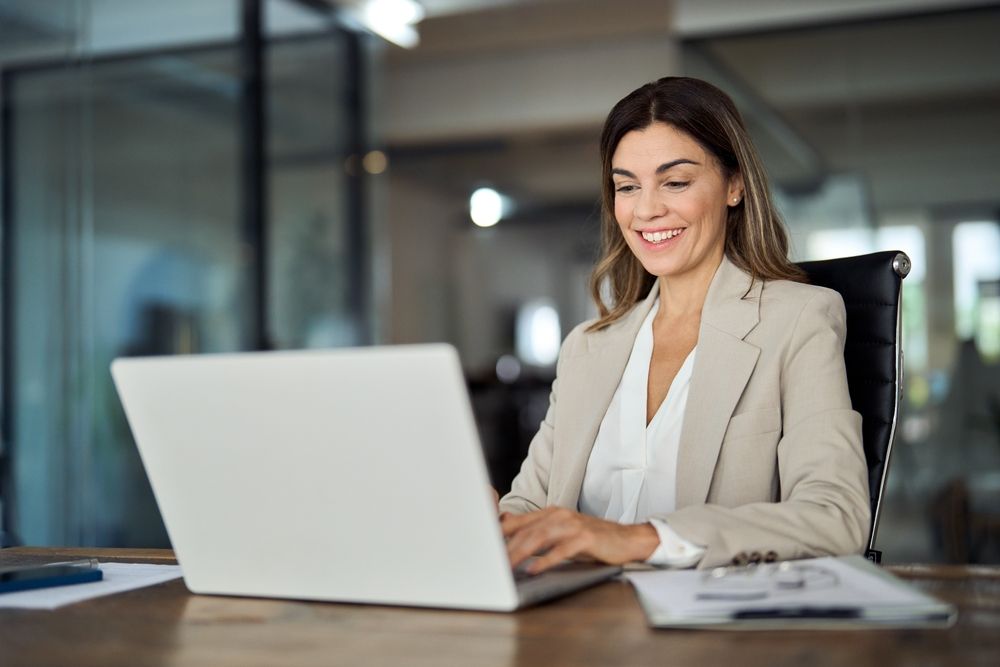 Professional working at a laptop while holding concurrent H-1B employment