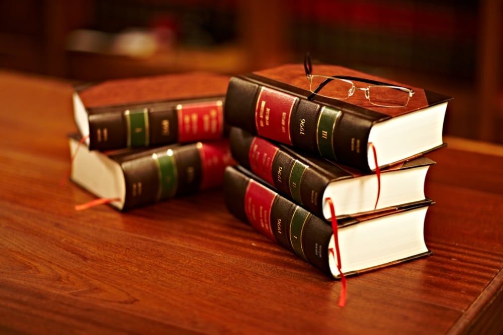 Stack of legal books on a desk in a law office.