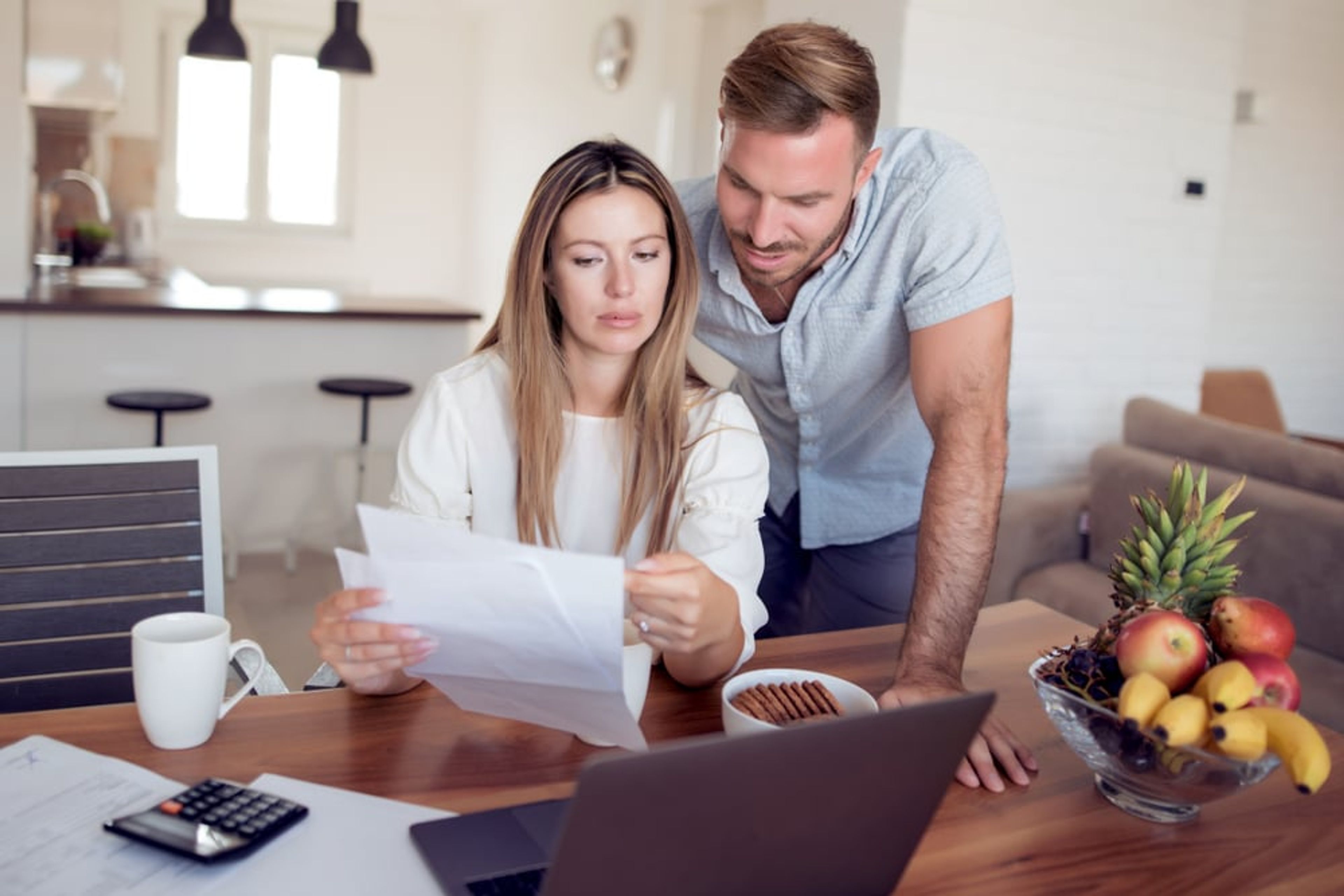 Young adult couple reading a form together in their kitchen