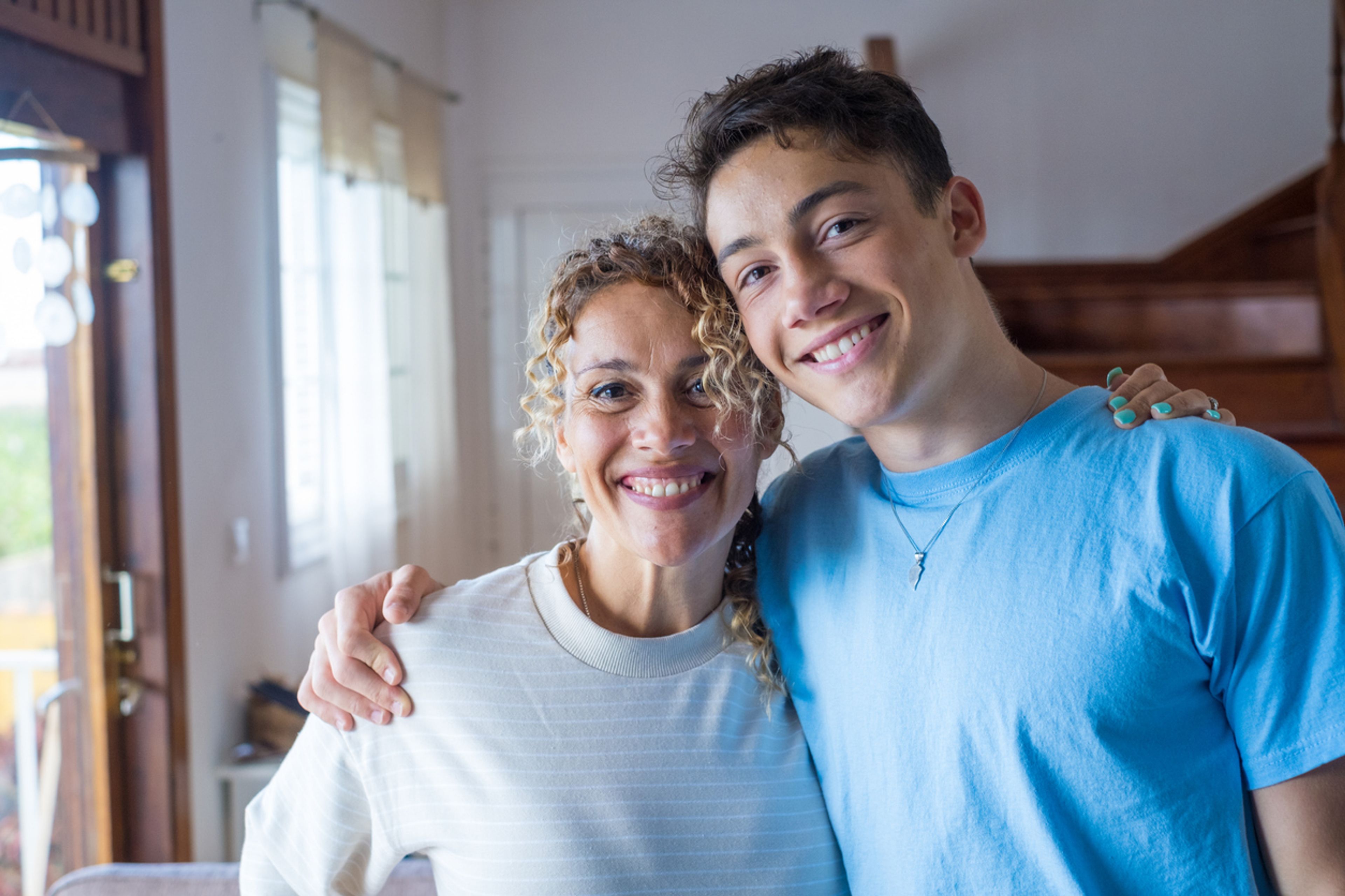 Young adult son with arm around his mother.