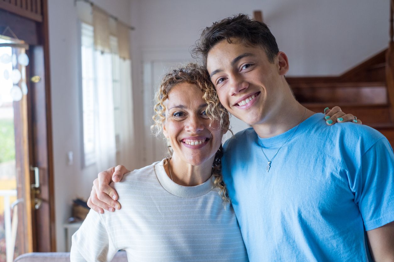 Young adult son with arm around his mother.