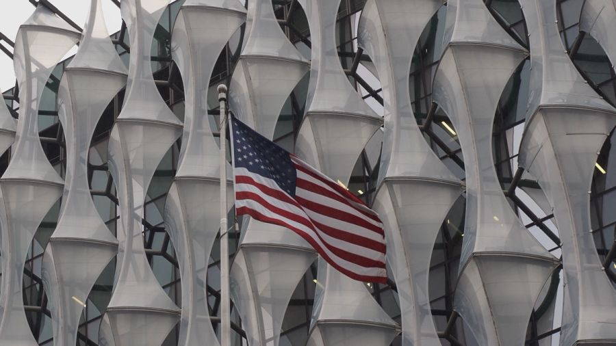 american flag against u.s. embassy background