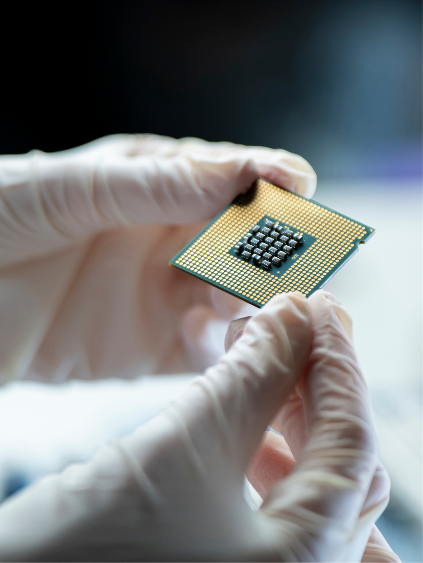 Gloved hands holding a computer processor chip