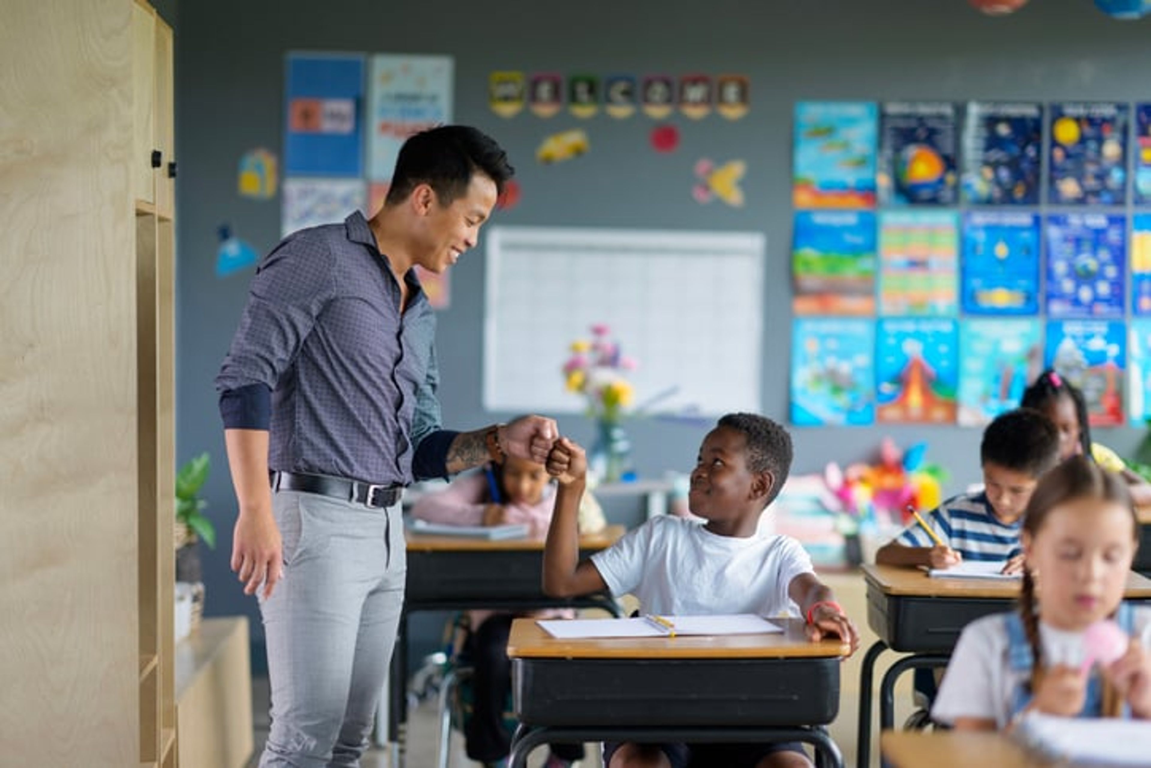 A teacher on an exchange visa fist bumps a student.