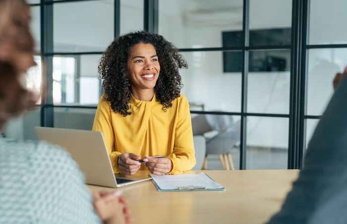 Middle aged businesswoman sits at an interview, considering a career change.
