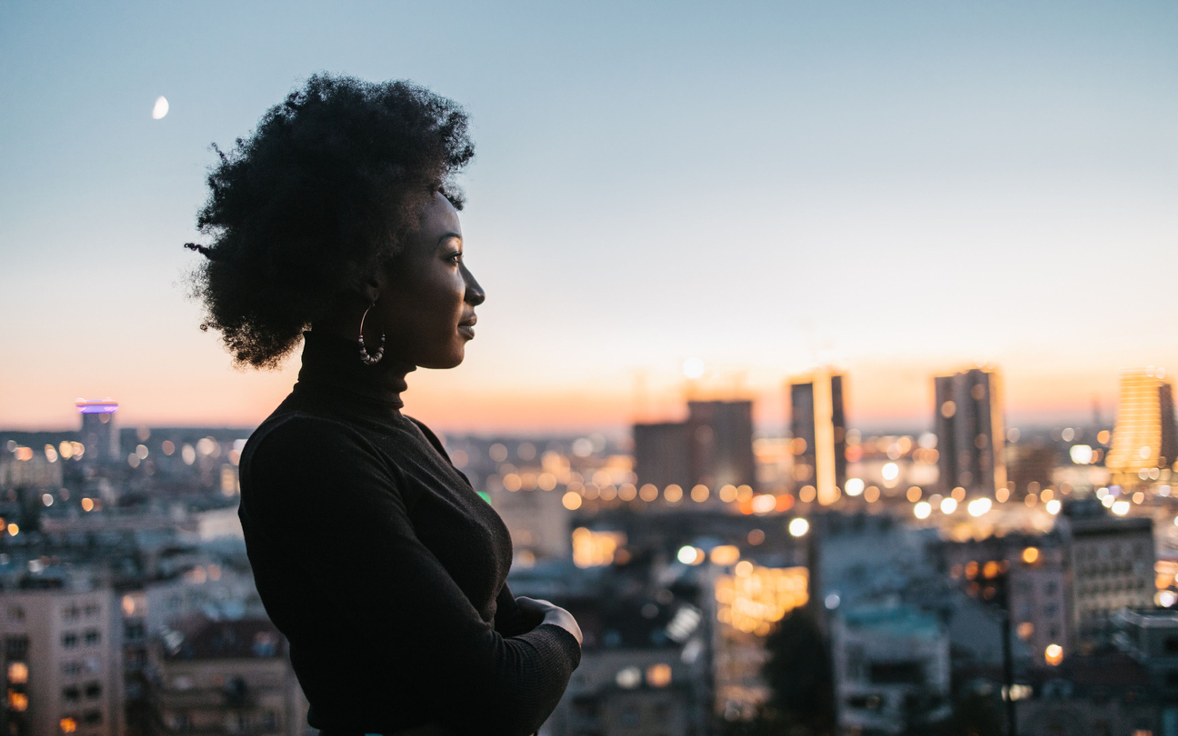Confident woman overlooking city skyline.