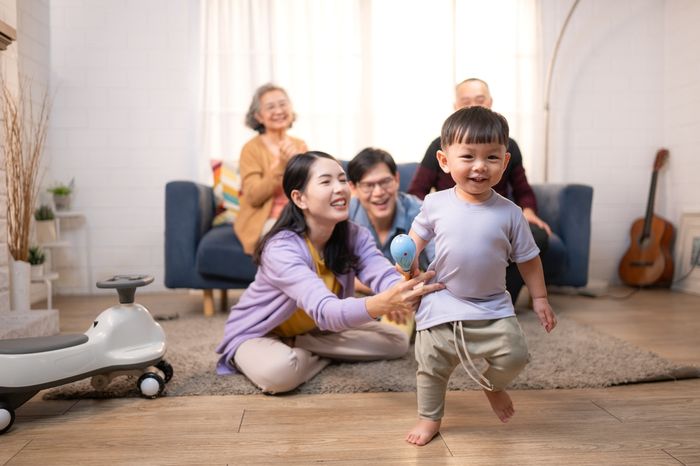 Multi-generational family including a young child, their parents, and their grandparents, in their living room.