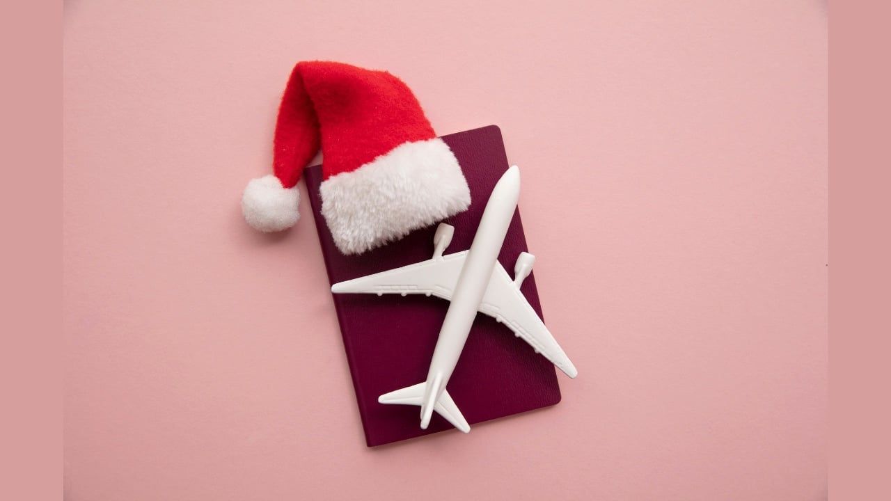 santa hat and airplane on red background holiday travel