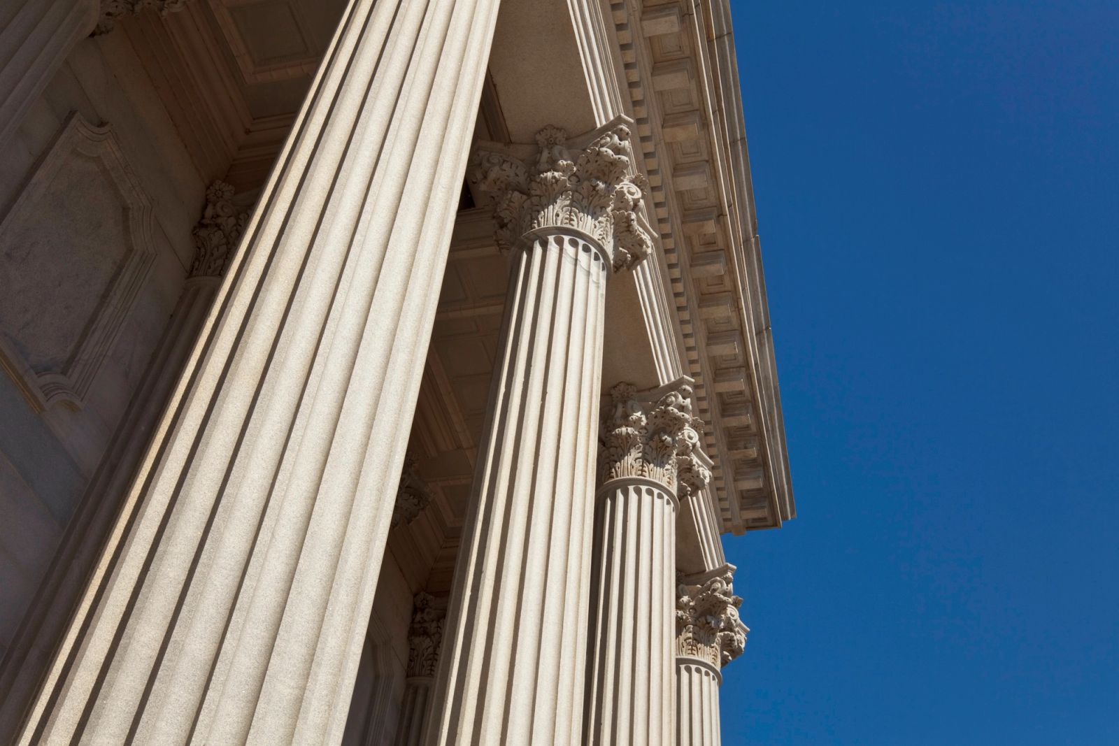Classical stone columns on a courthouse facade seen from below