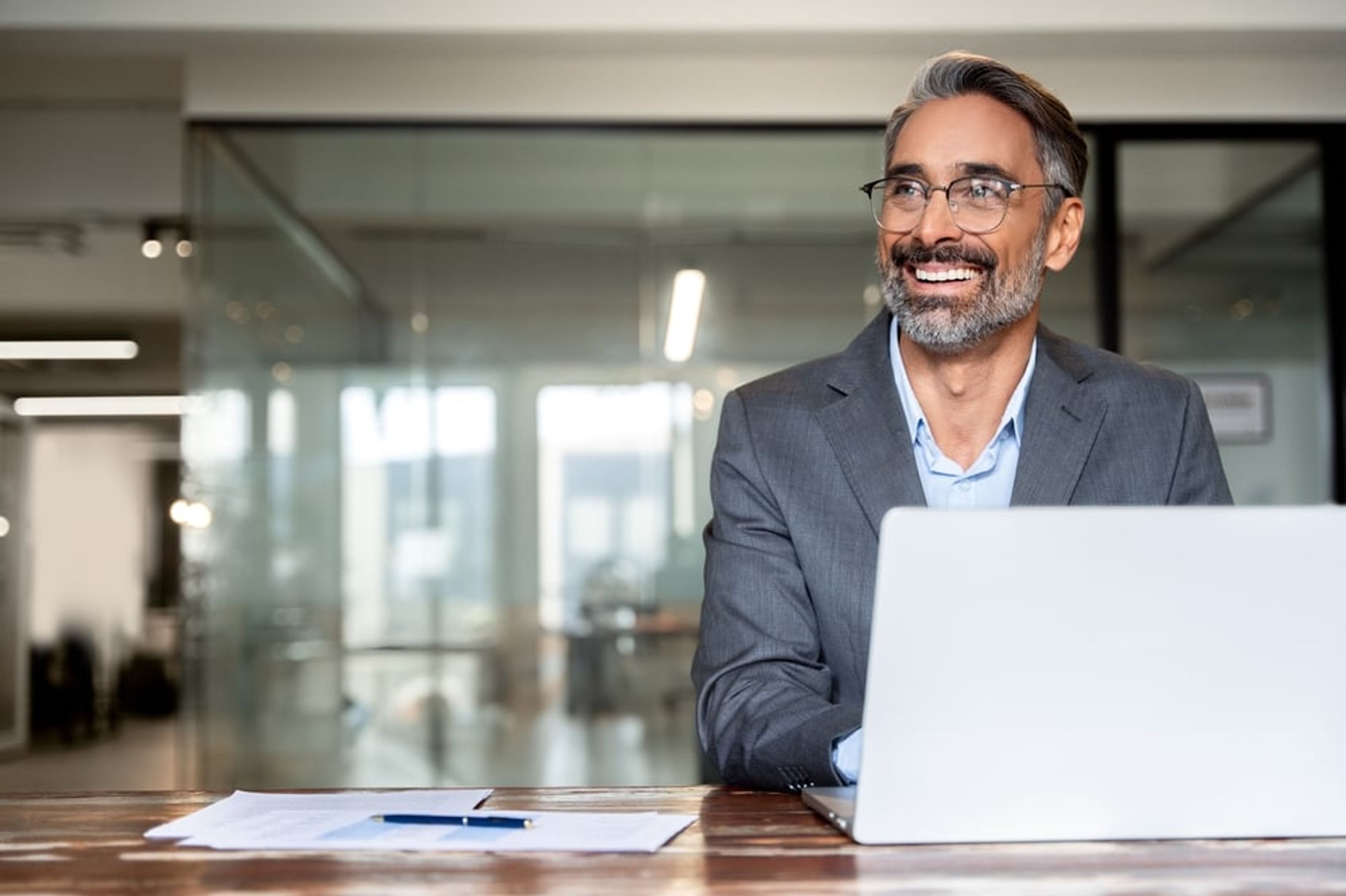 Smiling worker in an office using a laptop.