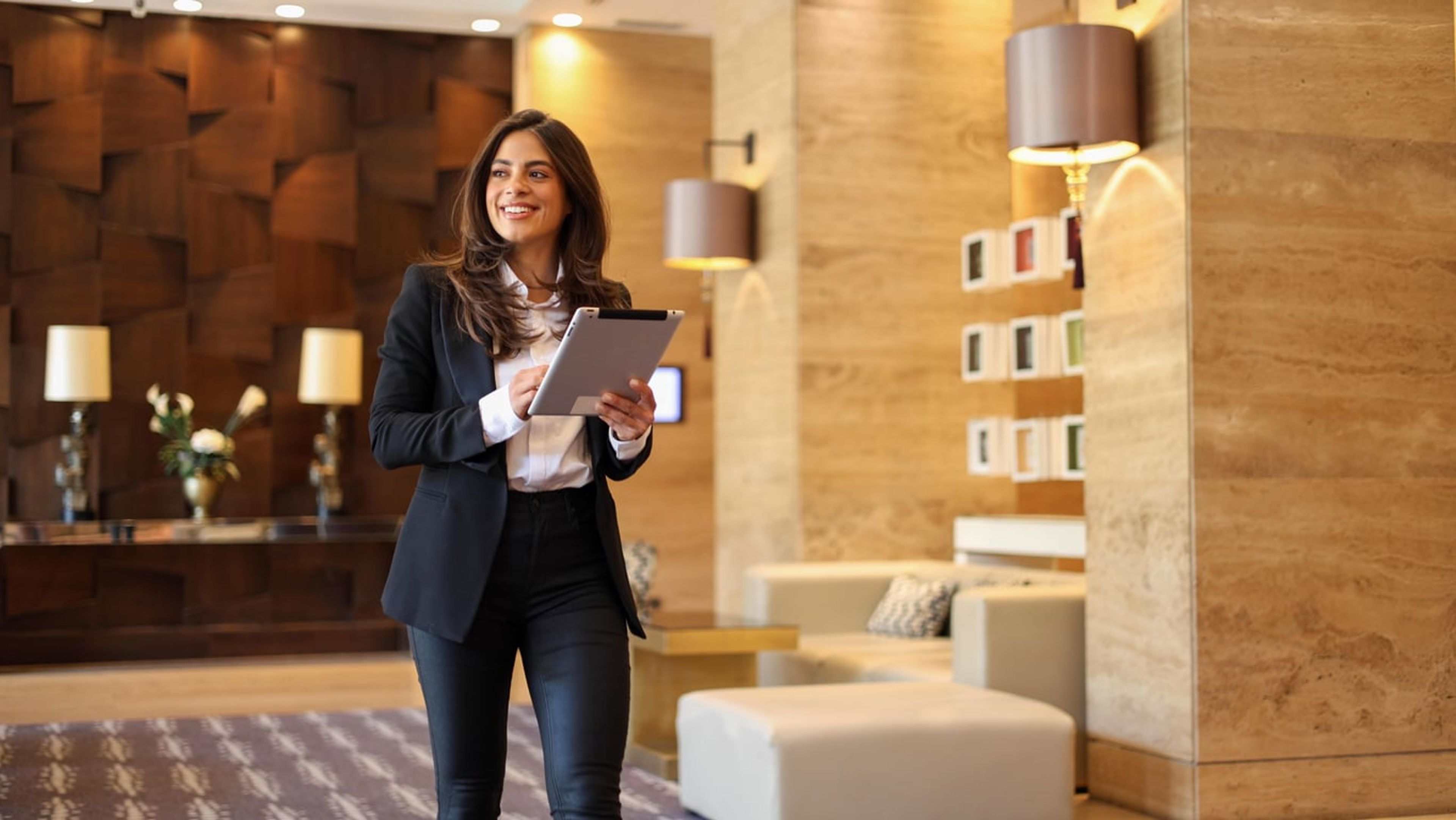 Businesswoman in a modern office reviewing information on her tablet device.