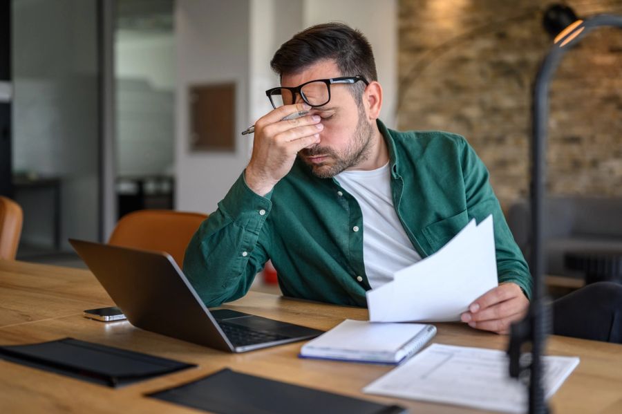 Concerned man looking over documents at his desk.