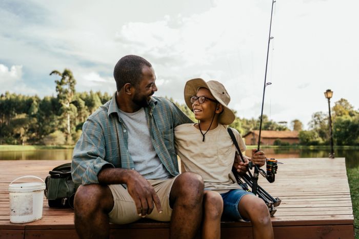 Father and son fishing in the lake relaxing and enjoying nature.