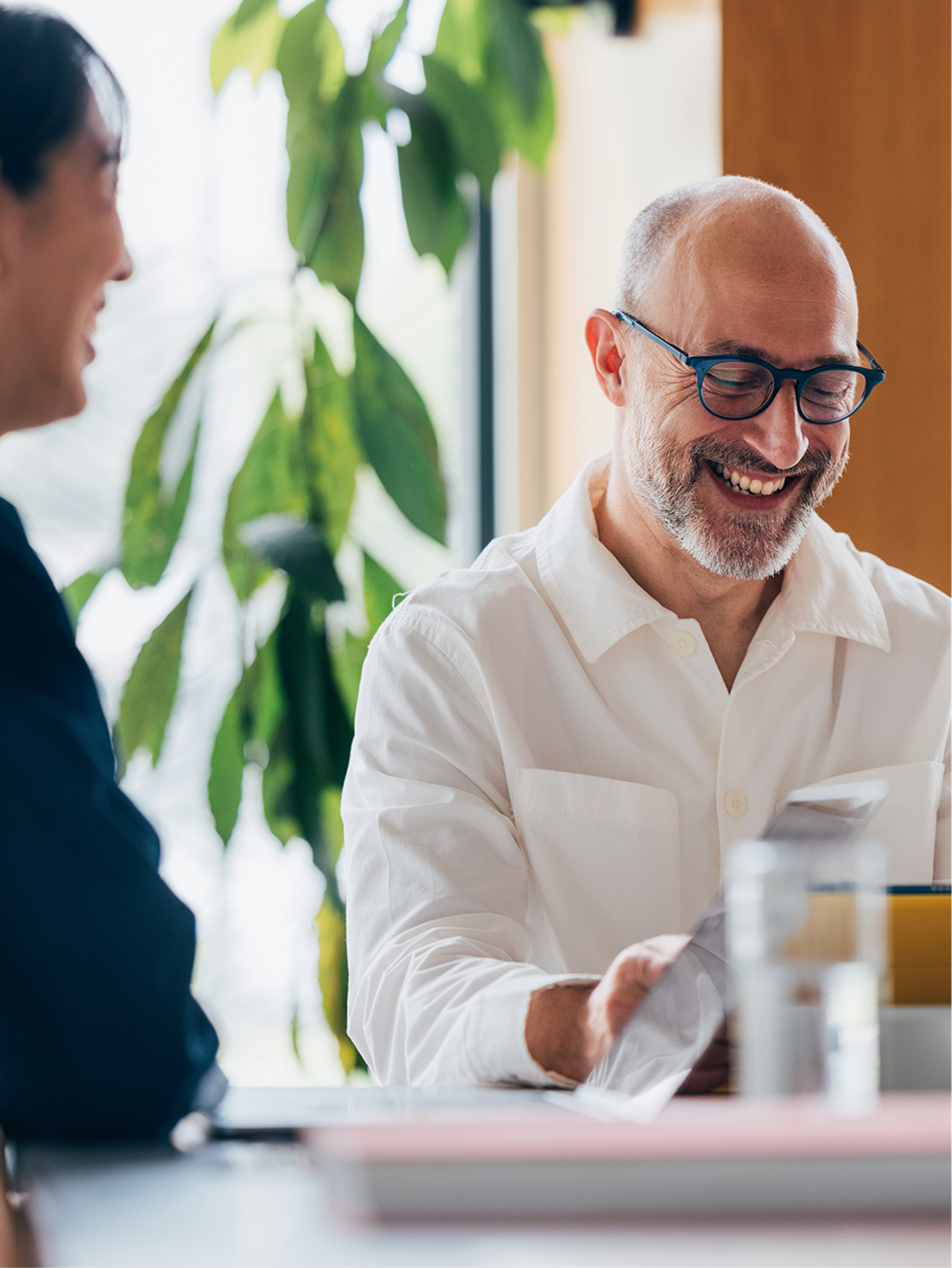 A founder smiling during a consultation over documents